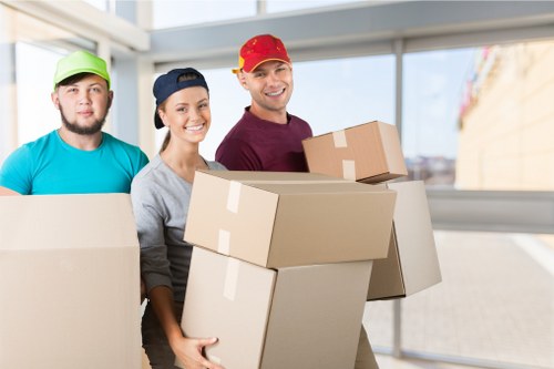 Professional commercial movers preparing desks and office equipment for relocation