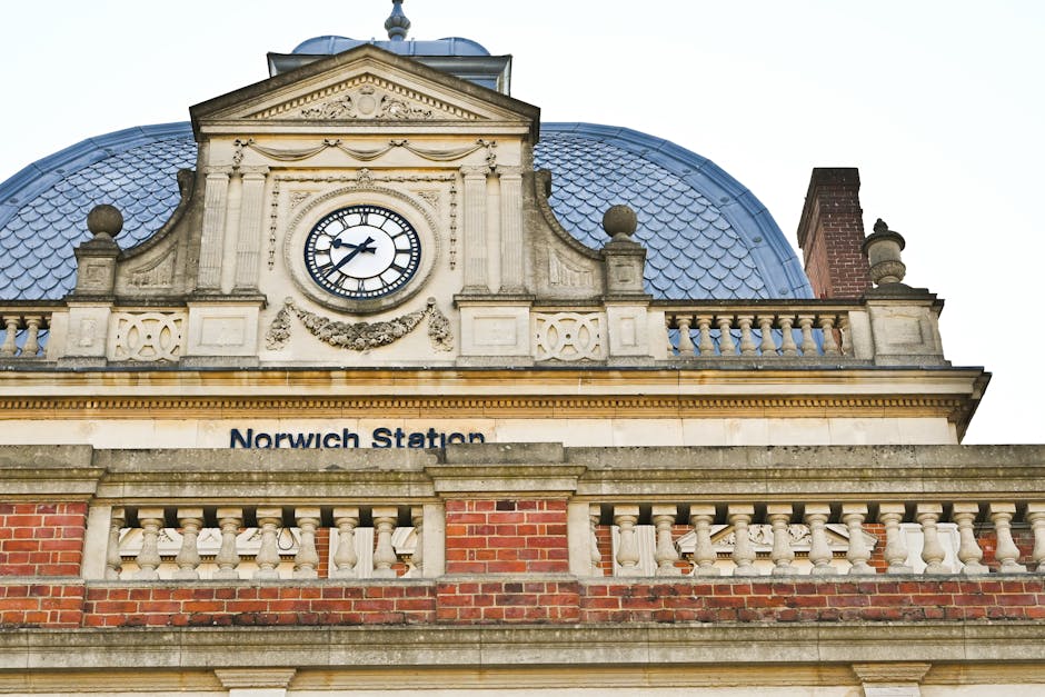 Inside an underground station, a flower stand operated by Wheeler of Chiswick displays a variety of colorful fresh flowers, including roses, sunflowers, and mixed bouquets arranged in metal buckets an